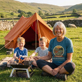 Woman in the Adventure Before Dementia Camping T-Shirt in Heather Deep Teal toasting marshmallows with two children at a Dales campsite