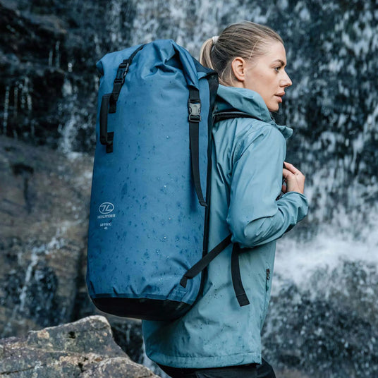 Highlander Affric Waterproof Rucksack in Blue - rear view worn beside a waterfall