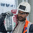 Bolle Contour Safety Glasses with clear lens worn by a construction worker in a white hard hat and hi-vis carrying a bag of screed
