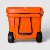Wheel end of the orange Orbie 55 cool box, two treaded wheels on a steel axle below a rope carry handle