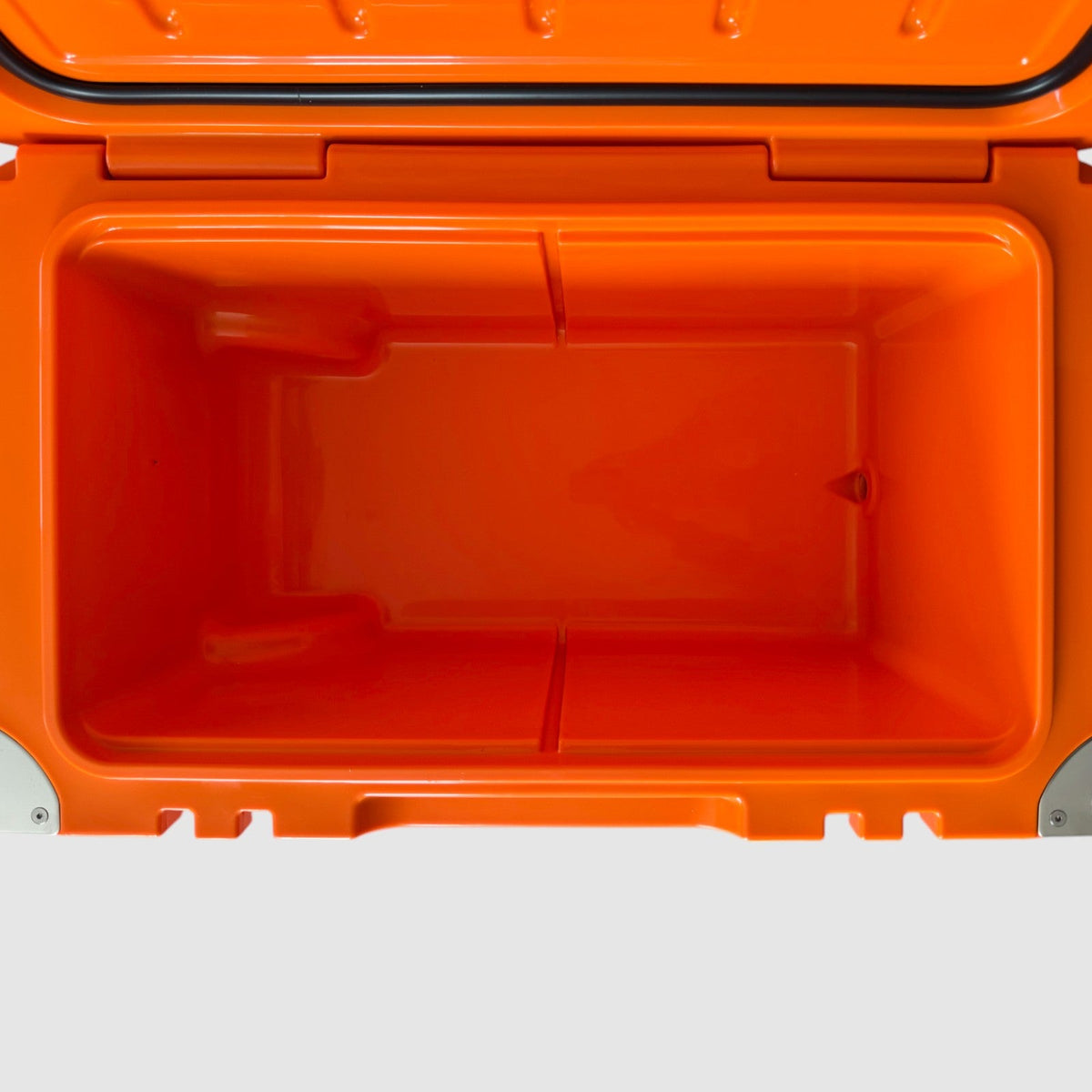 Empty interior of the orange Orbie 55 cool box, showing the moulded basket rails and the internal drain outlet