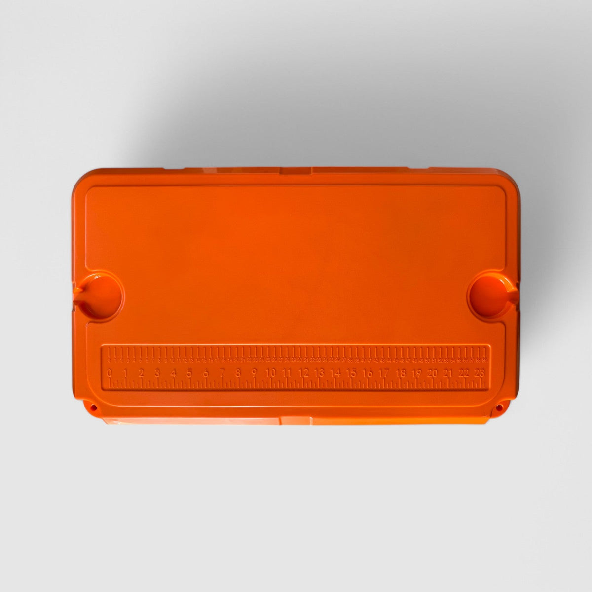 Top of the orange Orbie 55 cool box, showing the moulded ruler in centimetres and inches and a cup holder at each end