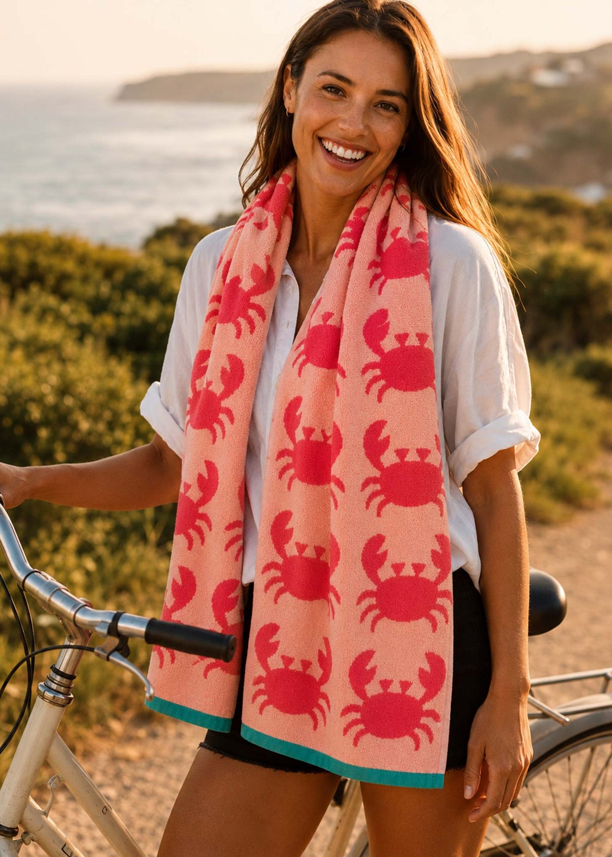 Anorak Crabs Organic Cotton Towel - Coral and blush pink carried to the beach