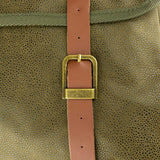 Jack Pyke Duotex Dog Bag in green, close-up of a tan leather strap and brass buckle on the pebbled Duotex