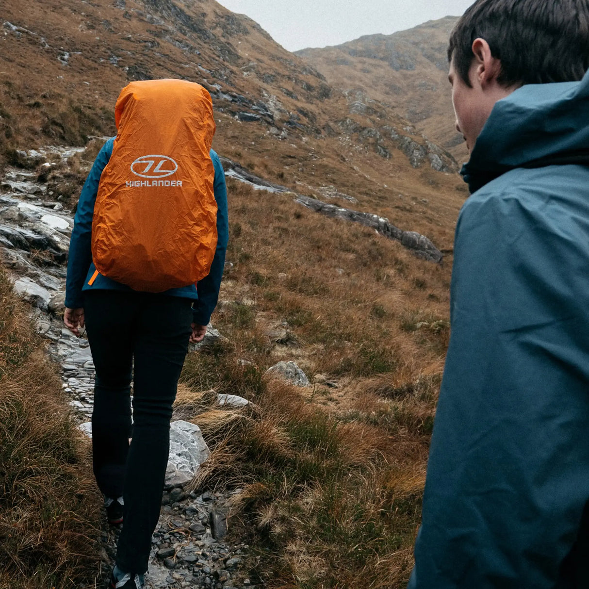 Highlander Duck's Back Waterproof Rucksack Cover in orange outdoors on a hike