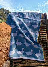 Anorak Waddling Ducks Organic Cotton Towel - Pale blue and yellow draped over a chair