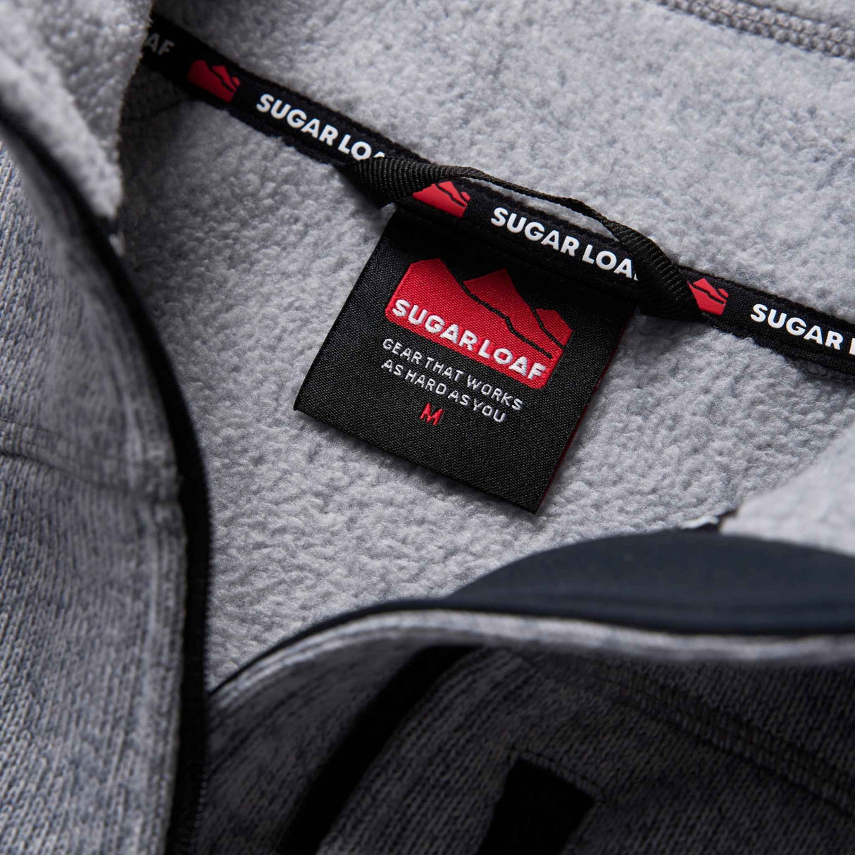 Sugar Loaf Fell Half Zip Fleece Top in Ash Grey close up of branding on collar