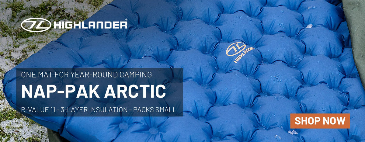 Highlander Nap-Pak Arctic R11 inflatable sleeping mat in deep blue on frosty grass – one mat for year-round camping, R-value 11, 3-layer insulation, packs small. Shop now.