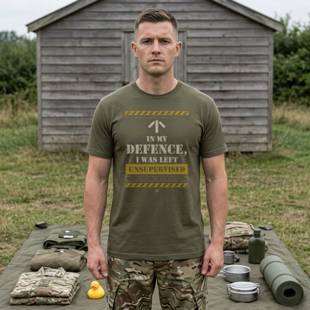 Man in Military Green "In My Defence, I Was Left Unsupervised" T-shirt behind a kit layout with a rubber duck