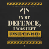 Close-up of the "In My Defence, I Was Left Unsupervised" print on Vintage Black: stencil slogan, yellow hazard stripes and Contents: 1 x Menace label