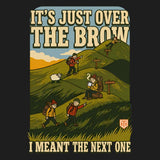 Close-up of the It's Just Over the Brow T-Shirt print: two walkers climbing a hill of false brows past a sheep, with a tea break and the line I meant the next one