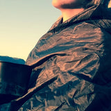 Close-up of the Snugpak Jungle Blanket WGTE in Olive Green showing the quilted Micro Diamond outer wrapped around a camper