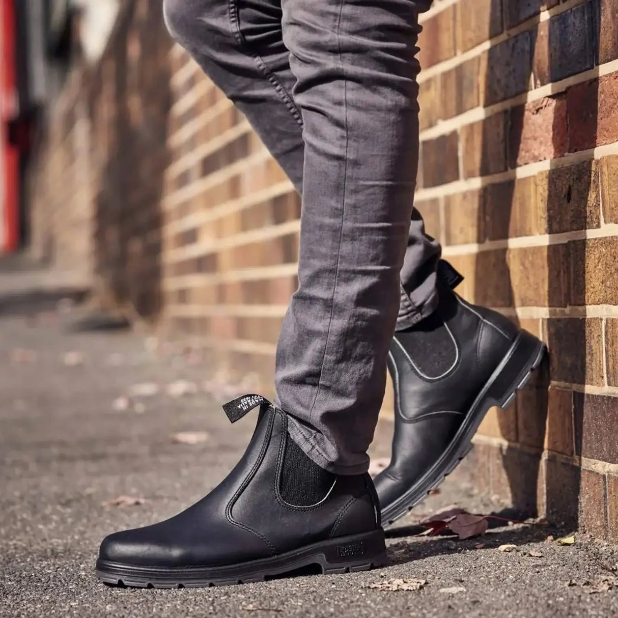 Mongrel K9 Dealer Boot - Black worn leaning against a brick wall
