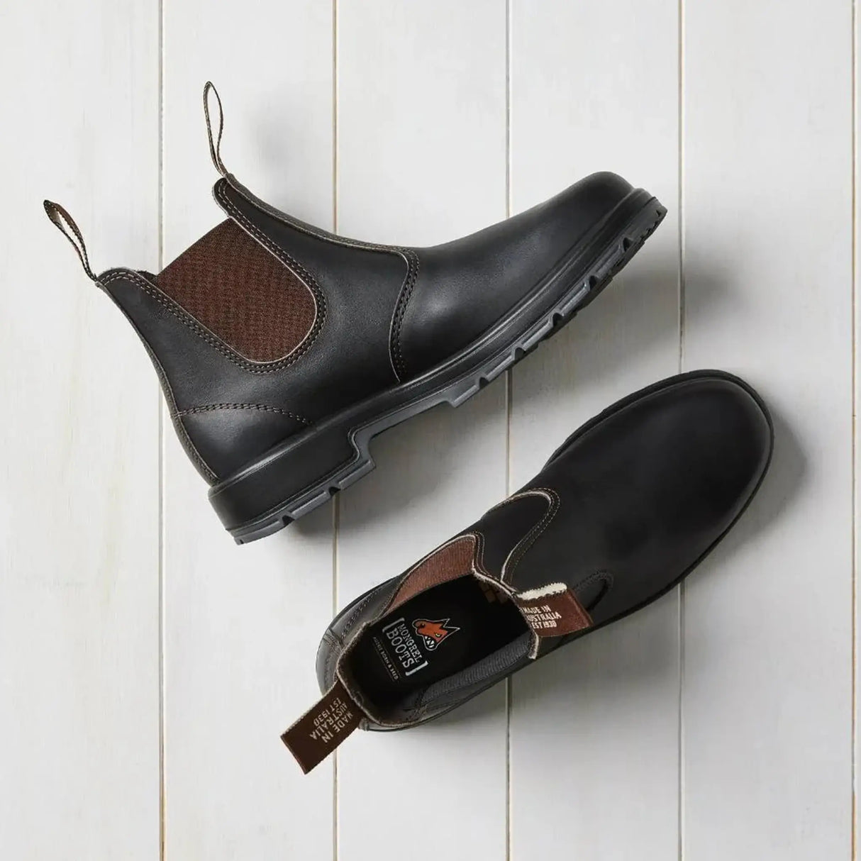 Overhead view of brown Mongrel K9 dealer boots, one flipped to reveal the cushioned insole and Mongrel logo