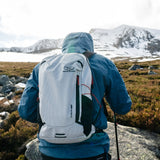 Highlander Kynetik Rucksack 15L in White - worn by a hiker with a walking pole below a snow-covered peak