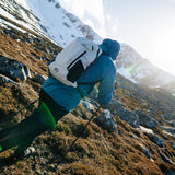 Highlander Kynetik Rucksack 15L in White - worn by a hiker traversing a rocky, sunlit mountainside