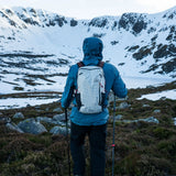 Highlander Kynetik Rucksack 15L in White - worn by a hiker with trekking poles above a frozen lochan