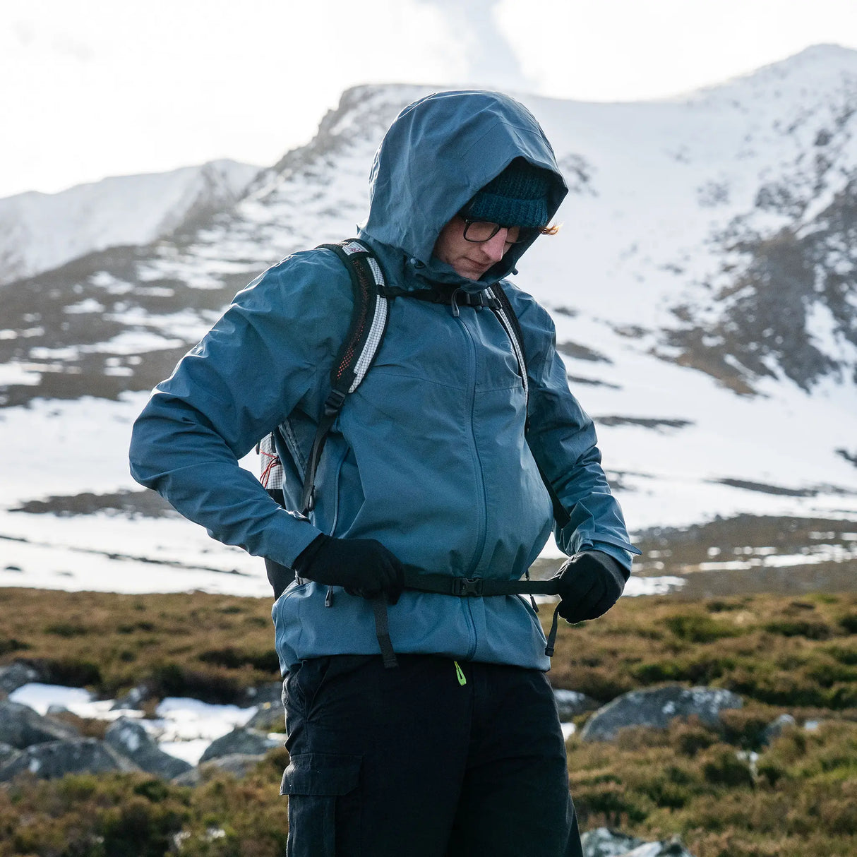 Highlander Kynetik Rucksack 15L in White - worn by a hiker fastening the waist belt on a snowy hillside