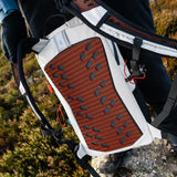 Highlander Kynetik Rucksack 15L in White - held to show the orange vented back panel and hydration port