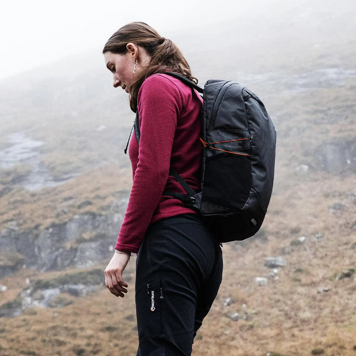 Highlander Kynetik Rucksack 20L in Black - side view worn by a hiker crossing open moorland