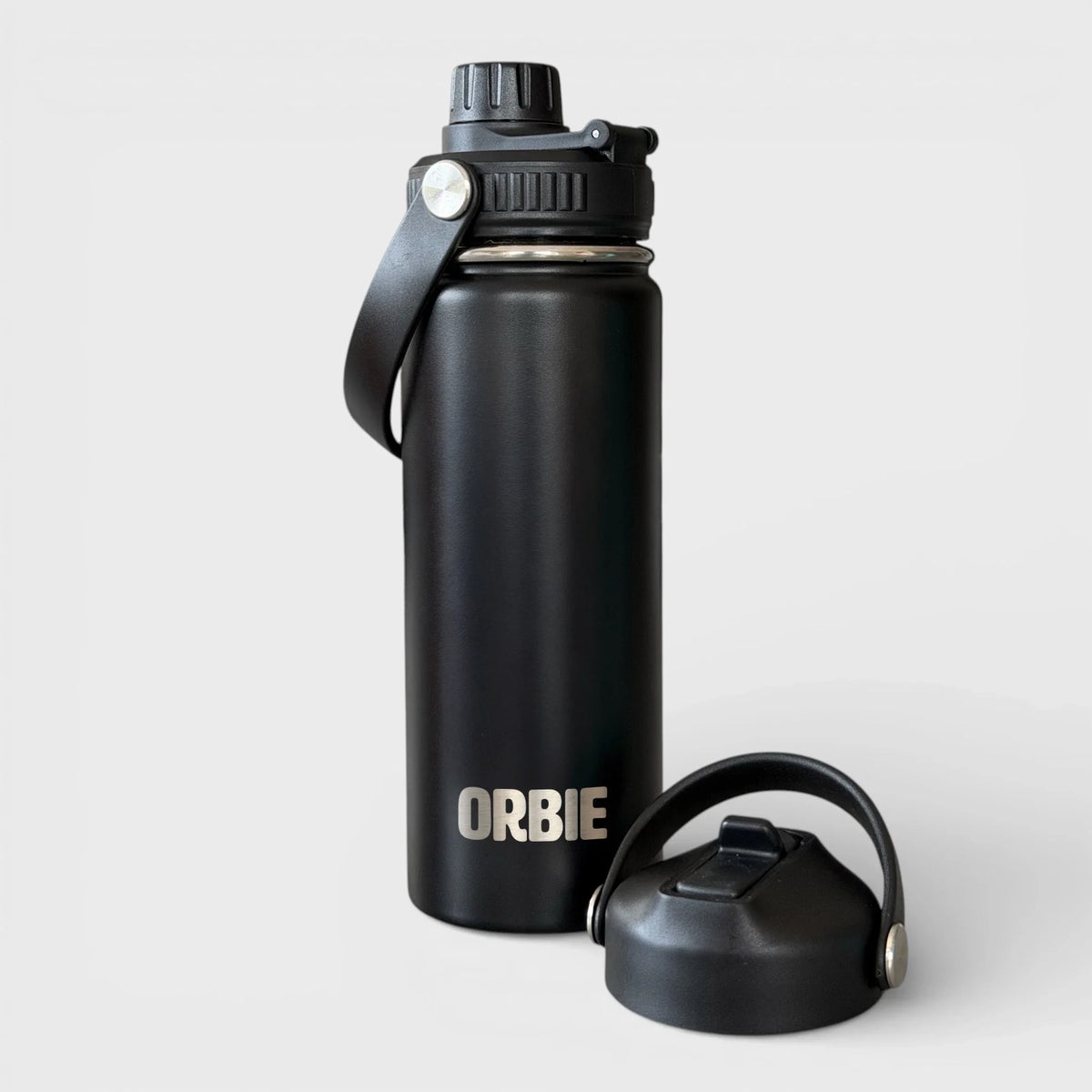 Orbie 18oz insulated water bottle in black with the chug lid fitted and the sip lid standing alongside