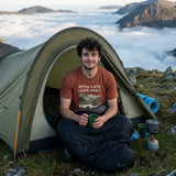 Wild camper sitting in his tent doorway above a sea of cloud in Snowdonia, wearing the Pitch Late Leave Early T-Shirt in Heather Clay