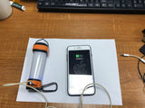 Skywoods L70931 Camping Lantern - charging a phone from the lantern on a desk