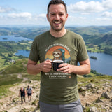 Man with a mug of tea on a Lake District fell top while his friends climb behind, wearing the Sloth Hiking Club: Hilltop T-Shirt in Military Green