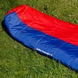 Snugpak Softie Expansion 2 WGTE Sleeping Bag in red and blue, zipped closed on grass with Softie Expansion 2 branding visible