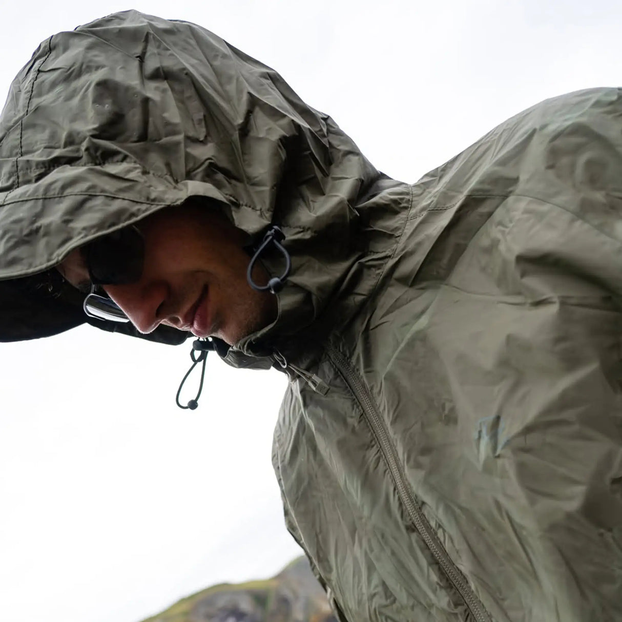 Highlander Stow & Go Pack Away Jacket - with hood up on man in the outdoors on rainy day