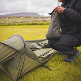 Snugpak Stratosphere WGTE Bivvi Shelter in Olive Green - camper packing the shelter into its compression sack