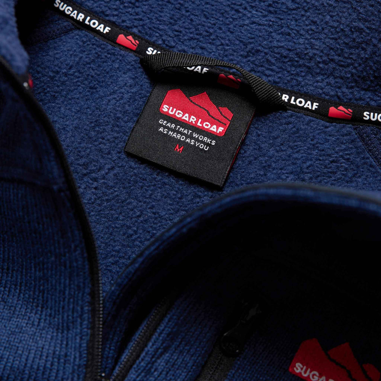 Sugar Loaf Fell Half Zip Fleece Top in Navy Blue close up of branding on collar