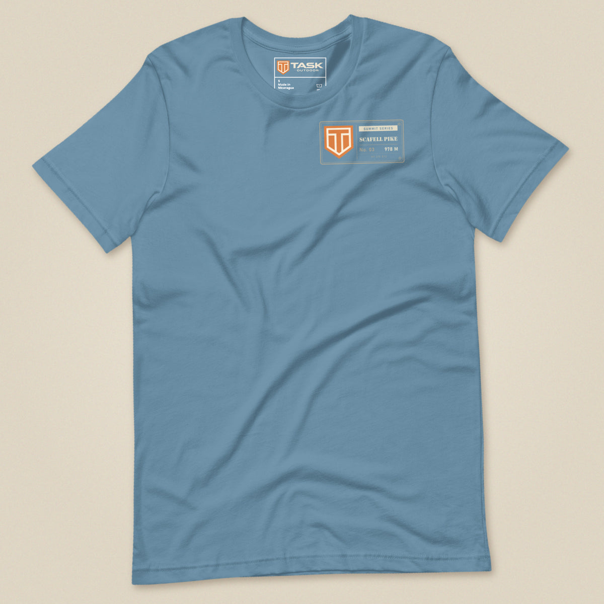 Summit Series Scafell Pike T-Shirt in Steel Blue, laid flat, front view with the left-chest badge