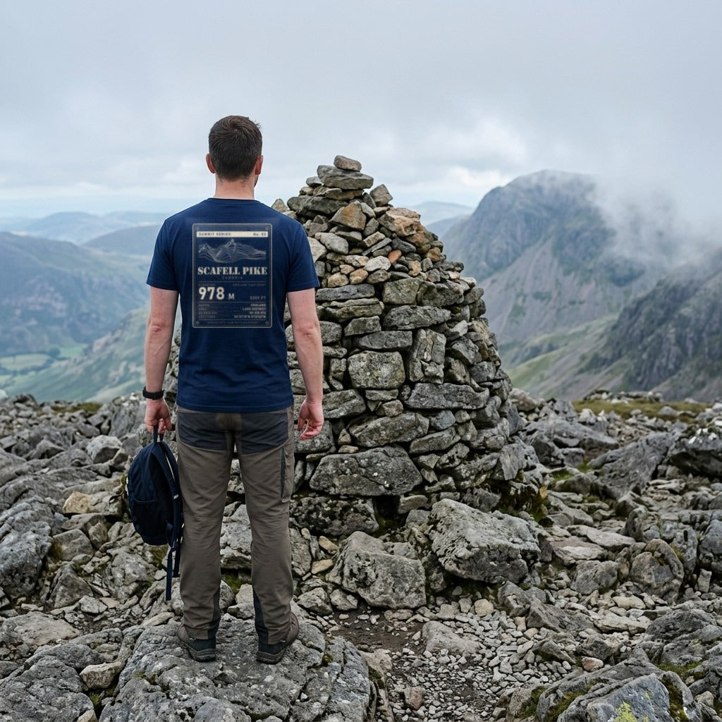 Walker in the Navy Scafell Pike T-shirt beside the summit cairn, showing the 978 m back print
