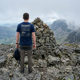 Walker in the Navy Scafell Pike T-shirt beside the summit cairn, showing the 978 m back print