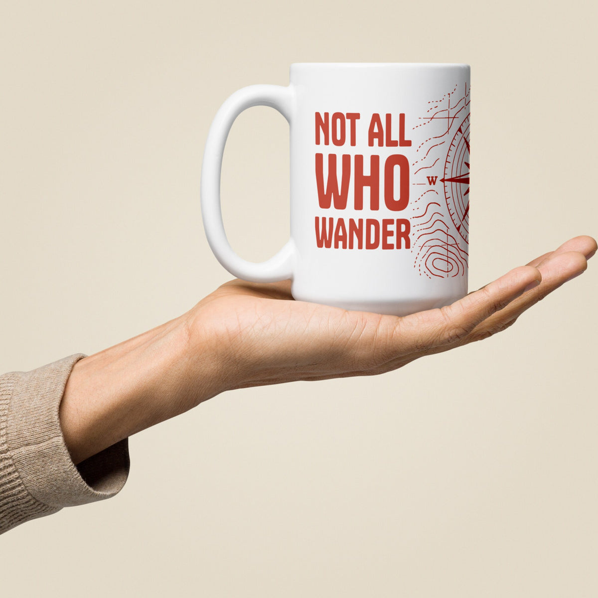 Not All Who Wander White Glossy Ceramic Mug in 15 oz, held in hand, handle on left