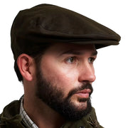 Jack Pyke Wax Flat Cap in green waxed cotton worn by a model, three-quarter left view