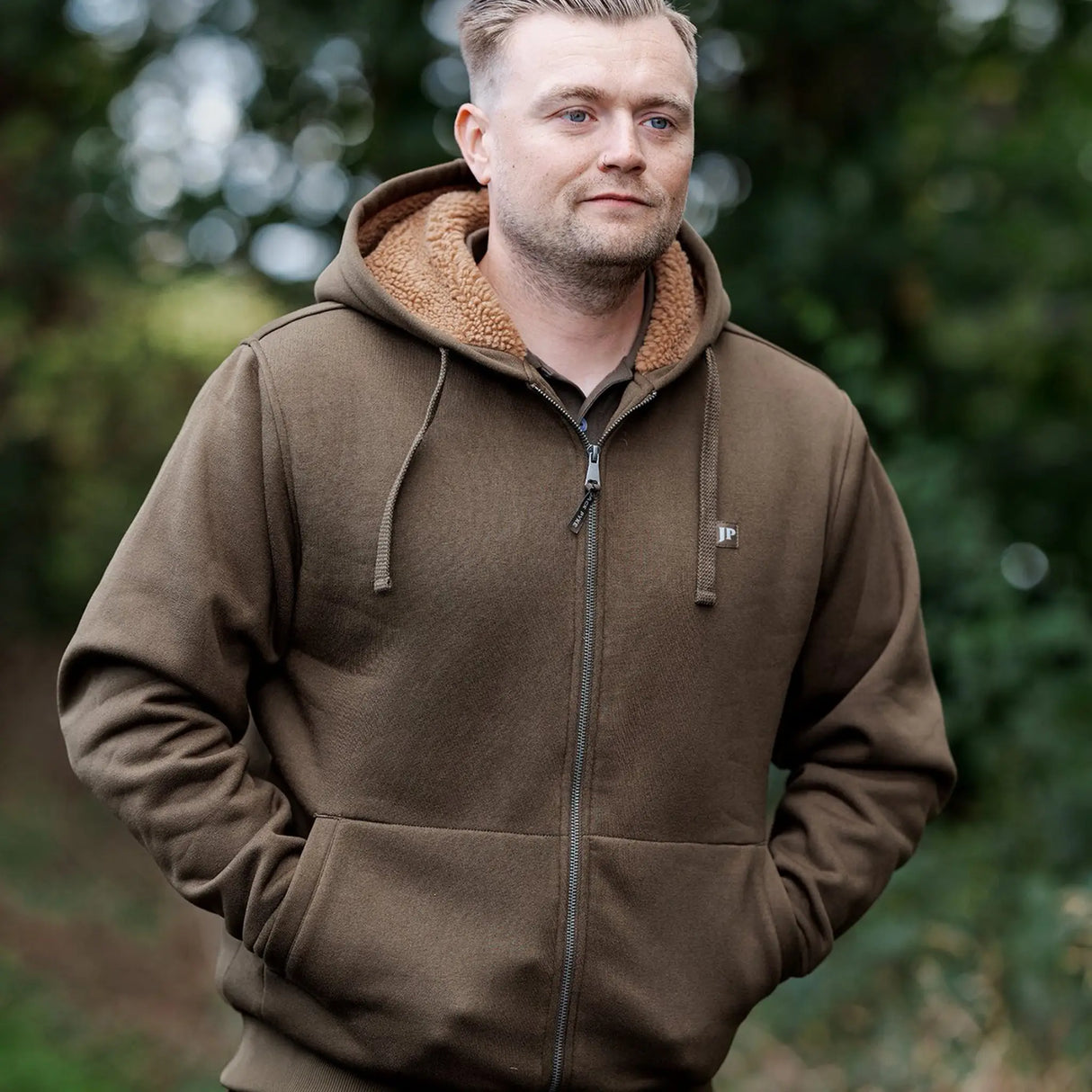 Jack Pyke Yakka Hoodie in olive green on a man hiking outdoors