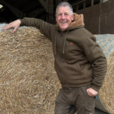 Jack Pyke Yakka Hoodie in olive green on a man working on a farm