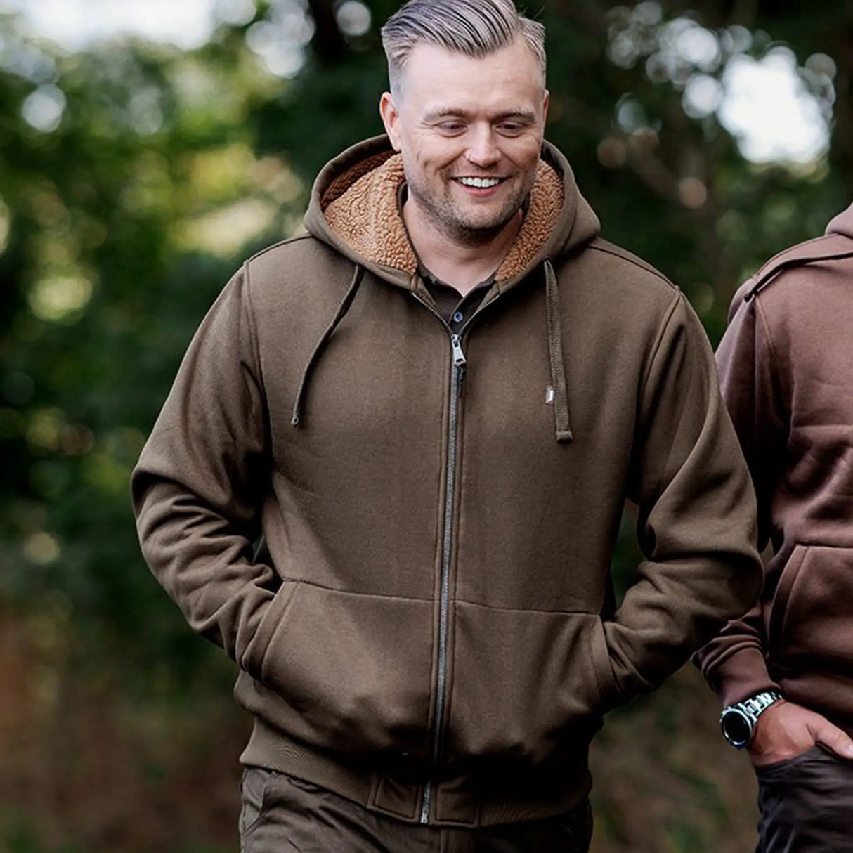 Jack Pyke Yakka Hoodie in olive green on a man walking outdoors
